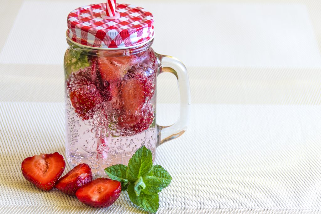 mineral water with strawberries, ice and mint in a vintage cup